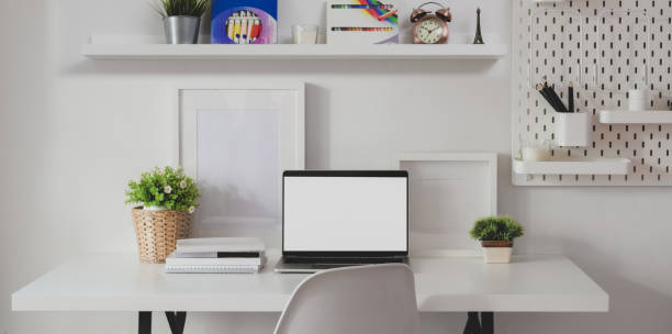 istock Minimal home-office room with open blank screen laptop computer with decorations 1180529583