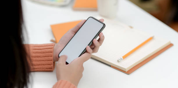 istock Close-up view of young female holding blank screen smartphone 1180529708