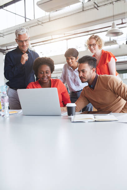 istock Focused group of diverse businesspeople using a laptop at work 1180530658