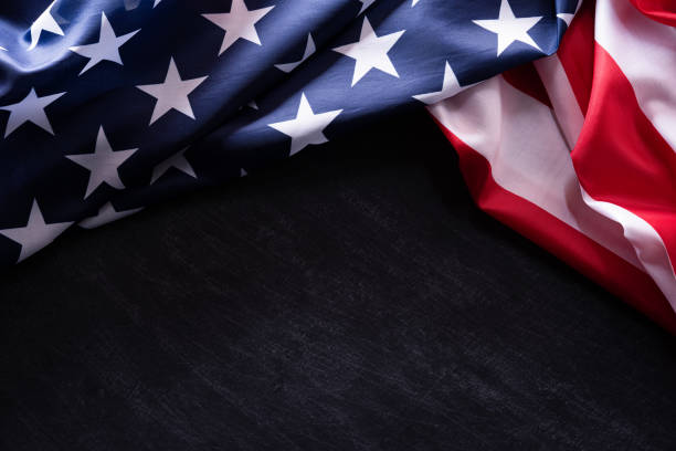 istock Happy Veterans Day. American flags veterans against a blackboard background. 1180532814