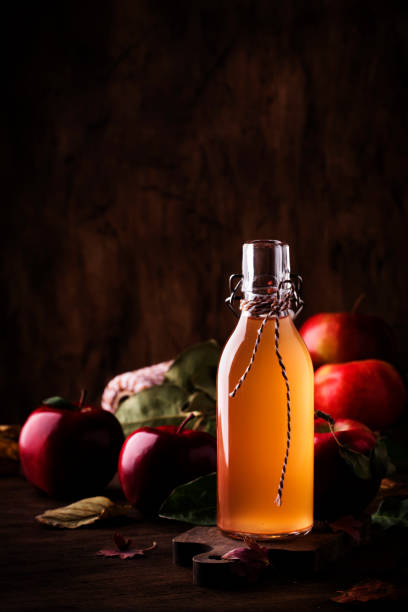 Apple vinegar. Bottle of apple organic vinegar made from fermented apples on wooden background. Healthy organic food. stock photo
