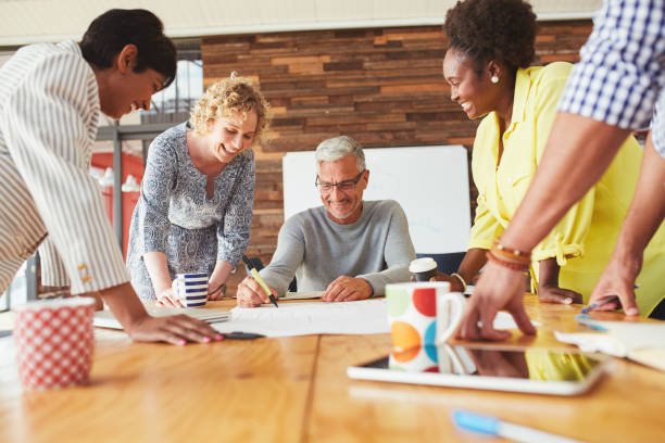 istock Smiling businesspeople putting ideas on paper during a brainstorming session 1180536557