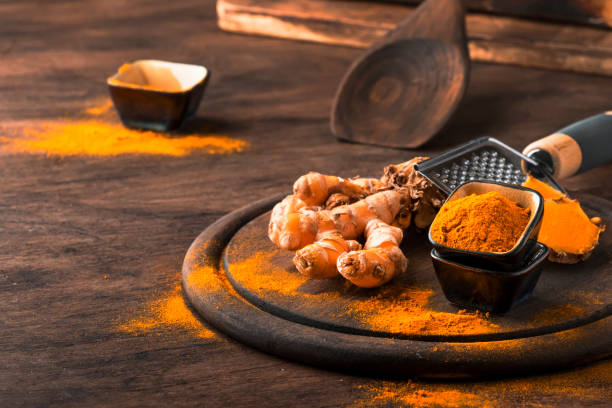 istock Turmeric powder and fresh turmeric on wooden background 1180537507