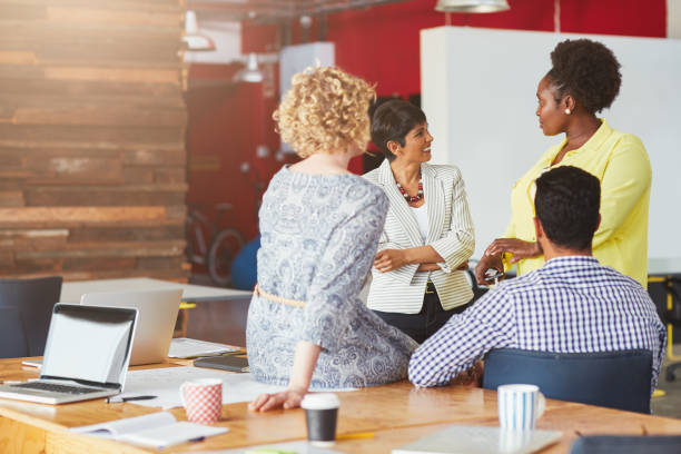 istock Smiling businesspeople talking together in a bright modern office 1180537568