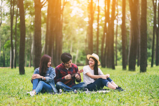 istock people playing ukulele while sitting together in the park 1180538282