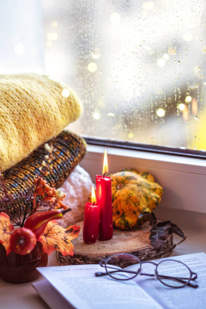 istock Autumn composition on a windowsill reading a book on a rainy evening. 1180545546