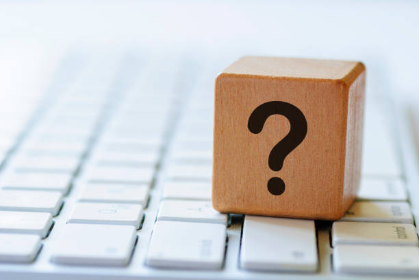 Small wooden dice with question mark on keyboard stock photo