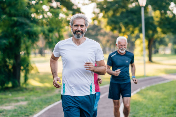 istock Smiling senior athletes jogging in the park 1180551832