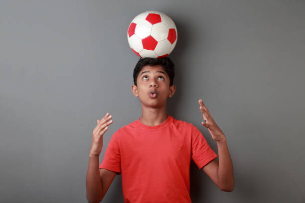 Boy balancing a soccer ball on his head