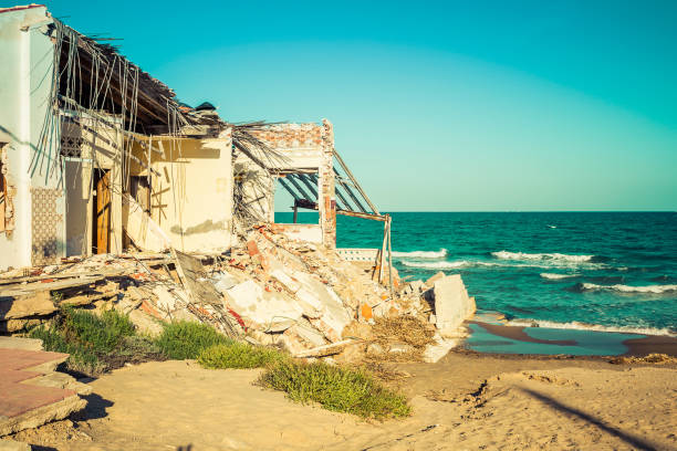 istock destroyed building on the beach after a storm due to strong waves. Climate change 1180554186