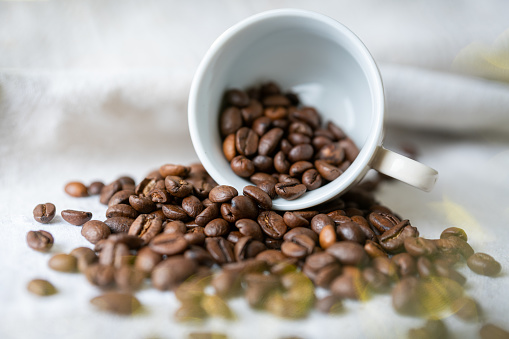 Espresso cup with coffee beans on a white cloth