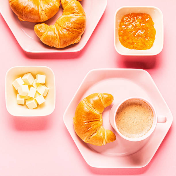 istock Coffee and croissants for breakfast on a pink background 1180555519