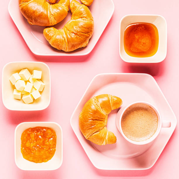 istock Coffee and croissants for breakfast on a pink background 1180555553