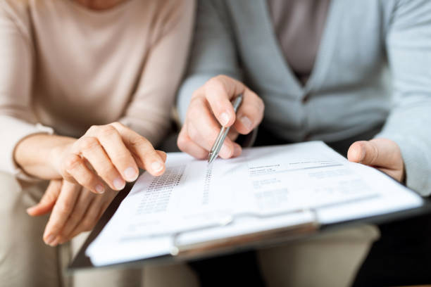 istock Human hands pointing at one of points of contract or other document 1180557564