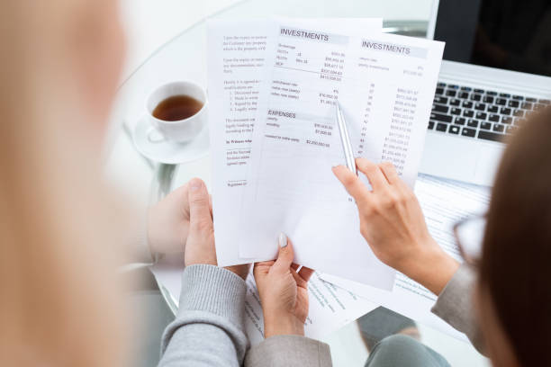 istock Hand of financial advisor with pen pointing at sum in document 1180558232