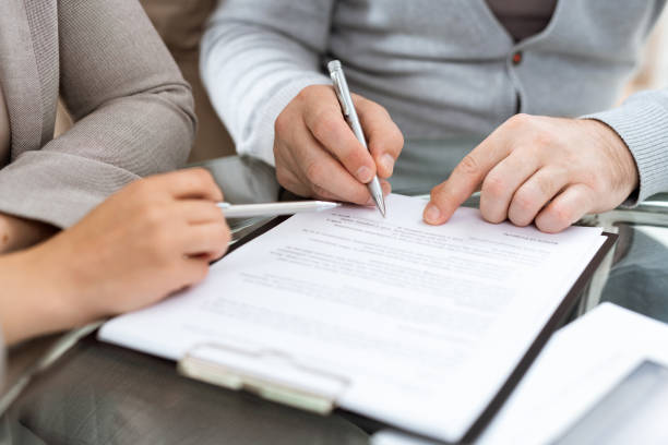 istock Mature man with pen going to sign contract or other financial document 1180558865