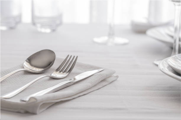 istock Table setting white and grey colour. Empty glasses and plates set with napkin and cutlery. Restaurant interior background. 1180560495