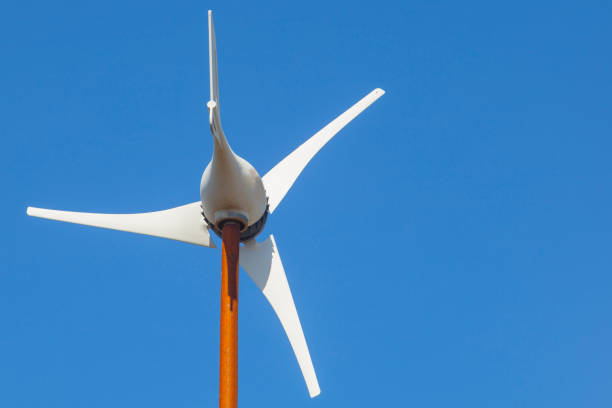 Domestic Wind Turbine mpunted over metalic pole Domestic Wind Turbine mpunted over metalic pole. Blue sky background 12v stock pictures, royalty-free photos & images