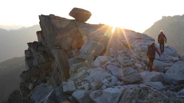 istock Mountaineers hike along rocky summit at sunrise 1180560711