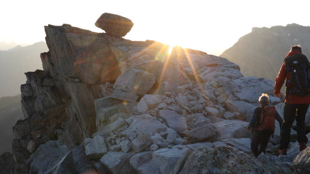 istock Mountaineers hike along rocky summit at sunrise 1180560724