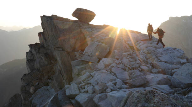 istock Mountaineers hike along rocky summit at sunrise 1180560734