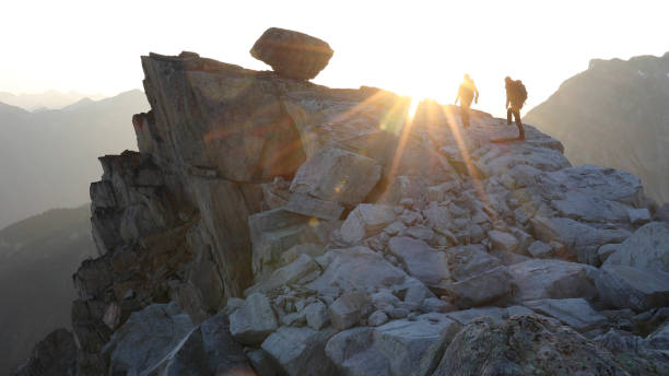 istock Mountaineers hike along rocky summit at sunrise 1180561401
