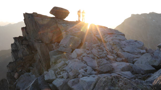 istock Mountaineers hike along rocky summit at sunrise 1180561431