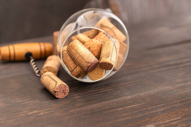 istock Wine glass with wine corks and  corkscrew on wooden table. Drinking wine concept. 1180561499