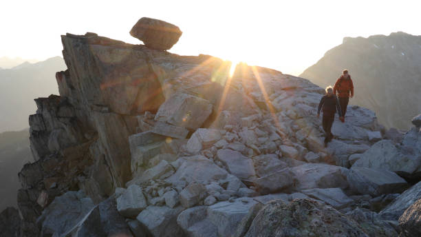 istock Mountaineers hike along rocky summit at sunrise 1180561763