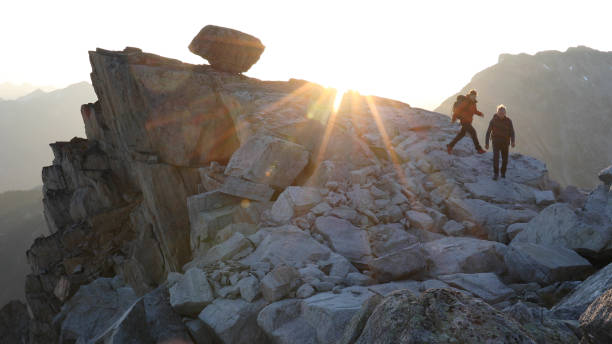 istock Mountaineers hike along rocky summit at sunrise 1180561772