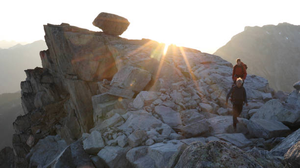 istock Mountaineers hike along rocky summit at sunrise 1180561790