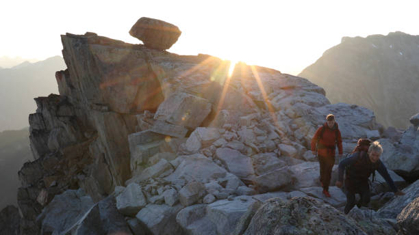 istock Mountaineers hike along rocky summit at sunrise 1180561920