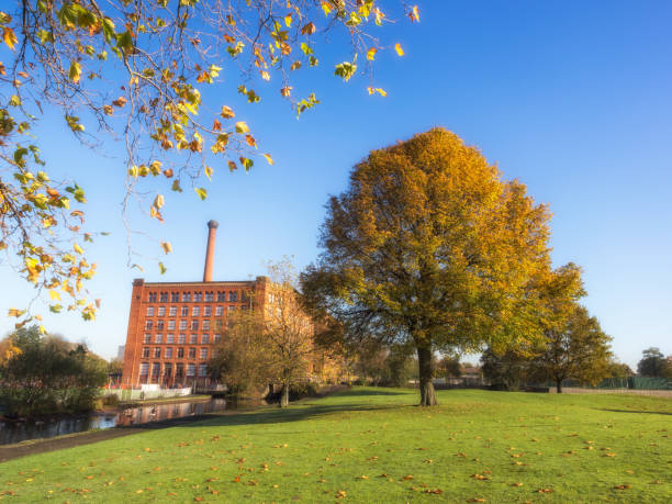 Mills Manchester An old English cotton mill alongside the canal in the autumn time in Manchester, England cotton mill stock pictures, royalty-free photos & images