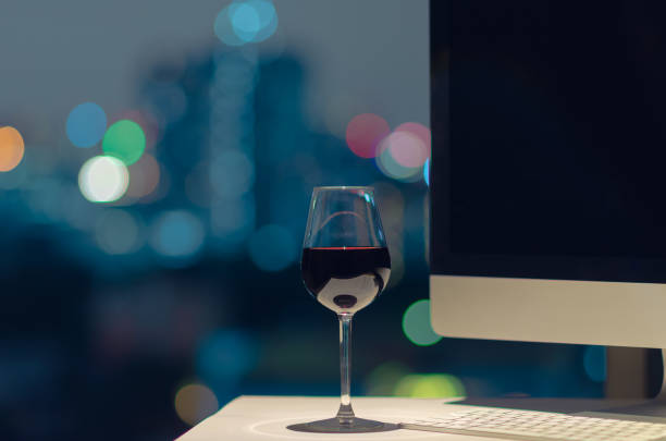 una copa de vino tinto puesta en la mesa de trabajo. - glass drink alcohol red fotografías e imágenes de stock