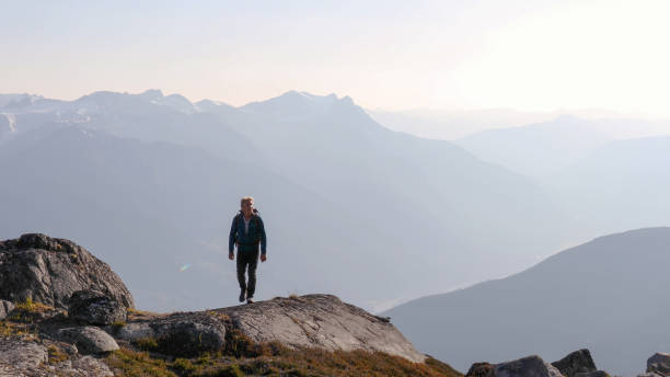 istock Mountaineer hikes along rocky summit at sunrise 1180563241
