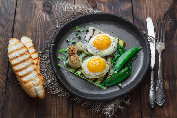 istock Fried sunny side egg with onion and snow peas, breakfast concept, dark photo copy space 1180570177
