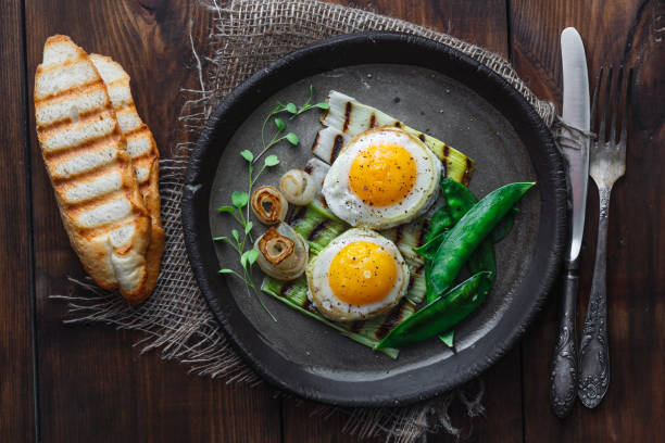 istock Fried sunny side egg with onion and snow peas, breakfast concept, dark photo copy space 1180570203