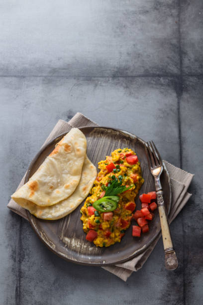 istock Indian Style scrambled eggs Akuri with paratha, dahl and ice tea, copy space 1180570284