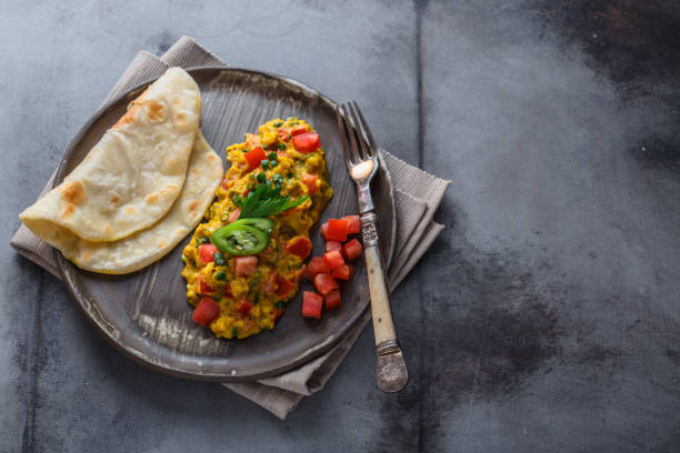 istock Scrambled eggs with tomatoes and chives on a plate, copy space 1180570286