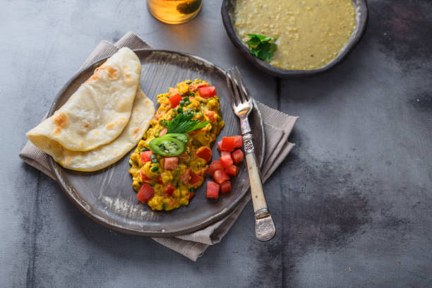 Indian Style scrambled eggs Akuri with paratha, dahl and ice tea, copy space