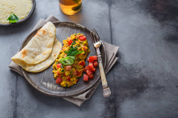 istock Scrambled eggs with tomatoes and chives on a plate, copy space 1180570302