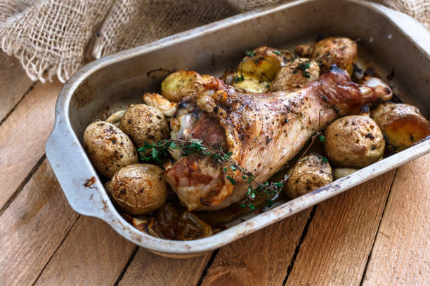 istock Oven baked turkey leg with potato and spices, rustic style, top view 1180571459