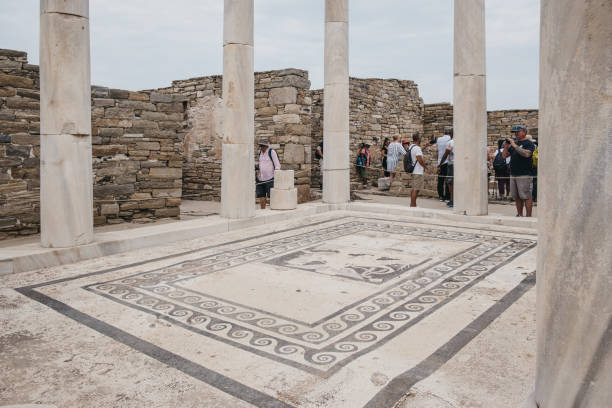 people walking around house of dionysos ruins on the island of delos, greece. - mosaic greek culture mythology ancient imagens e fotografias de stock