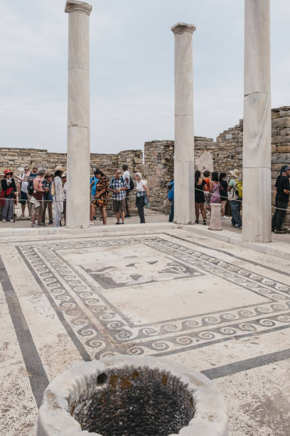 persone che camminano intorno alle rovine della casa di dioniso sull'isola di delos, in grecia. - greek mythology goddess mosaic greek culture foto e immagini stock