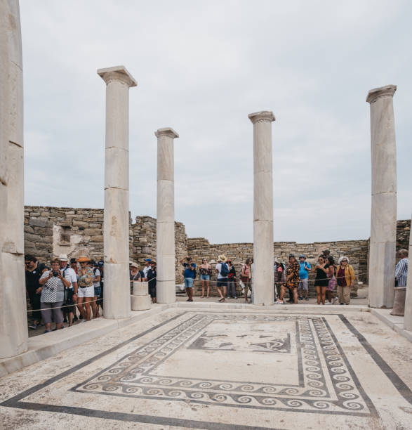 persone che camminano intorno alle rovine della casa di dioniso sull'isola di delos, in grecia. - greek mythology goddess mosaic greek culture foto e immagini stock