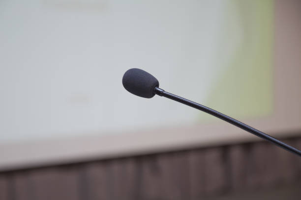 istock Speaker prepare before speaking to the audience behind the podium focused microphone on the podium and blurred empty seat and some of audience . Speech or conference concept. 1180575910