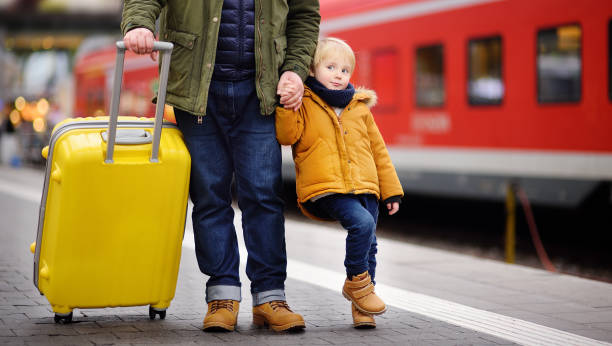 istock Smiling little boy and his father waiting express train on railway station platform 1180576555