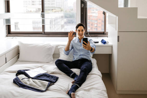istock Businessman video chatting using mobile phone at hotel 1180582822