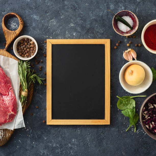 istock Cooking table with blank chalk board beef meat, vegetables, spices, herbs top view Food menu 1180583398
