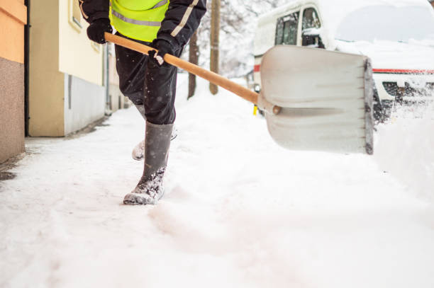 istock Man with snow shovel cleans sidewalk 1180583404